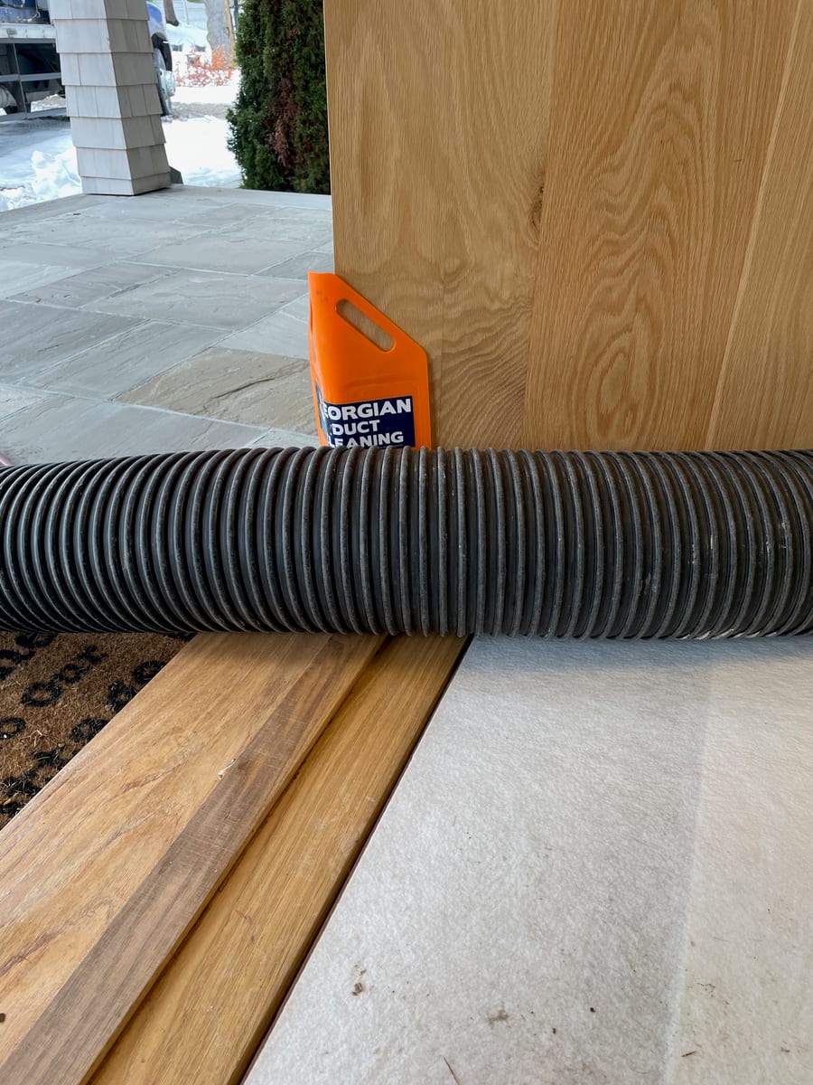 Corner guard protecting a door frame during duct cleaning